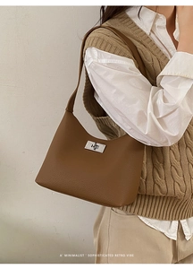 Detail shot of a dark brown pebble leather shoulder bag styled with a neutral outfit