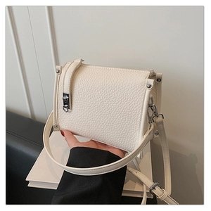 Detailed macro view of the cream white litchi pattern leather bag and silver side rivets