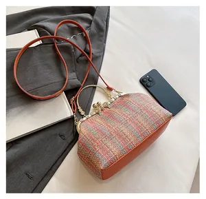 Détail du sac coquille tissé multicolore avec cuir orange et fermoir fleur en cristal