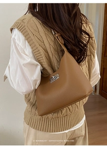 Detailed close-up of brown pebbled leather bucket bag featuring a silver metal twist lock