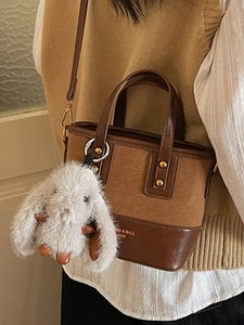 Sac seau vintage en cuir marron avec charm lapin en peluche gris et deux poignées chic