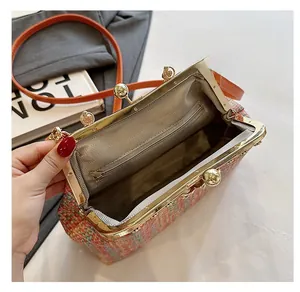 Détail de l'intérieur d'un sac en tweed coloré avec cadre métal et poche zippée