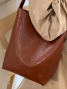 Vintage caramel brown oil-wax leather bucket bag for women with minimalist shoulder strap