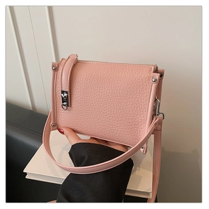 Detail view of pink lychee leather handbag showing silver lock and fine stitching texture