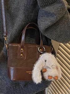 Sac seau vintage en cuir marron avec charme de lapin en peluche et détails dorés