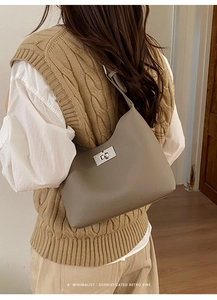Detail of taupe pebbled leather shoulder bag with minimalist silver twist lock clasp