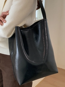 Classic black glossy faux leather bucket bag with wide shoulder strap for women