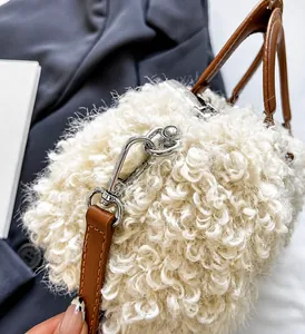 Dettaglio borsa di peluche bianca con tracolla in pelle marrone e fibbia argento