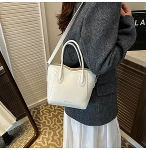 Vue détaillée d'un sac seau trapèze blanc avec bords ondulés et texture en similicuir