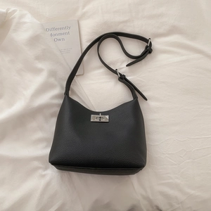 Detailed macro view of black lychee grain leather bag with a silver metallic turn-lock