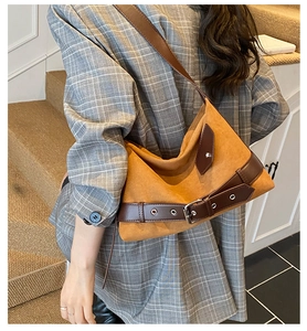Modèle portant un grand sac cabas en daim moutarde avec des détails en cuir marron