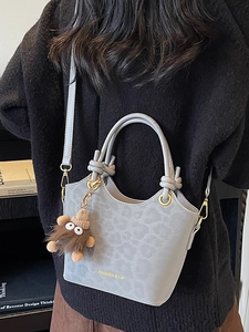 Borsa a secchiello grigia leopardata con manico a nodo e ciondolo indossata