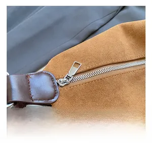 Vue détaillée de la fermeture éclair en argent et texture daim marron sur le sac à main