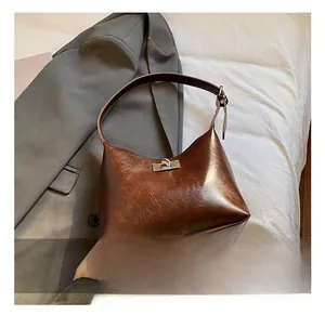 Close-up of a vintage dark brown leather shoulder bag with metallic silver turn-lock