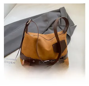 Gros plan d'un sac à bandoulière en daim vintage avec boucle décorative en cuir
