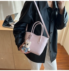 Mini sac seau lavande avec breloque ours sur un bureau dans un décor de bureau