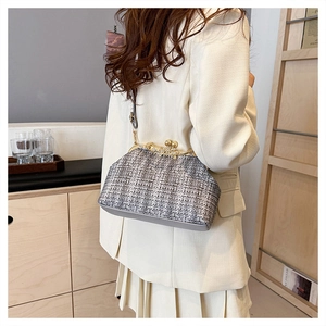 Pochette vintage en tweed avec fermoir perle et chaîne portée par un mannequin chic