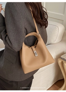 Detail view of camel lychee grain leather bucket bag with silver lock and shoulder strap