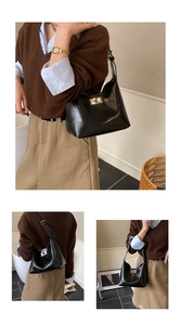 Detail of minimalist black hobo bag with silver square twist lock and smooth glossy finish