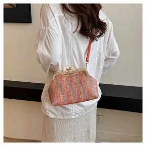Détail d'un sac à bandoulière tissé coloré rétro avec fermoir perlé et lanière en cuir