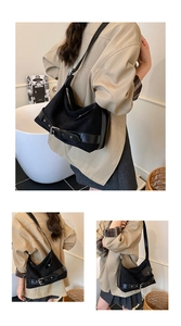 Détail du sac hobo en daim noir avec boucle en métal argenté et sangle de réglage