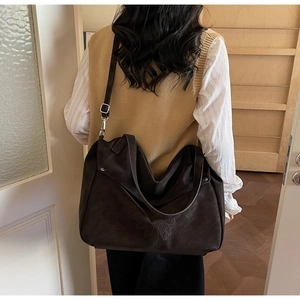 Detail of floral embossed texture and adjustable strap on large vintage brown tote bag