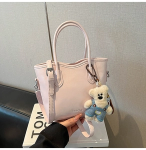Gros plan du sac seau rose avec logo de la marque et pendentif ours mignon