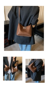 Detail view of brown faux leather shoulder bag set with silver metallic twist lock closure