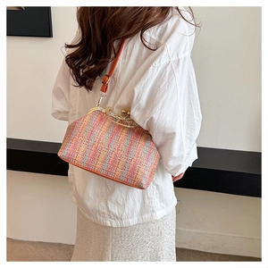 Détail du sac en tweed tissé coloré avec fermoir doré et bandoulière en cuir orange