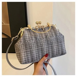 Détail d'un sac à main en tweed gris avec fermoir doré orné de strass et fleurs