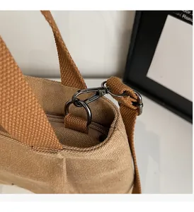 Detail of high-quality dark grey metal buckle and durable fabric strap on canvas bag