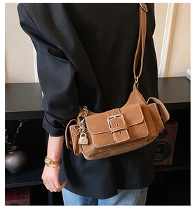 Detail of vintage brown suede baguette bag with multi-pocket design and adjustable strap