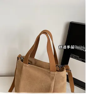 Detailed view of brown thick canvas bag featuring reinforced handles and adjustable strap