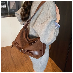 Gros plan d'un sac cabas en daim marron avec garniture en cuir et détails de boucle