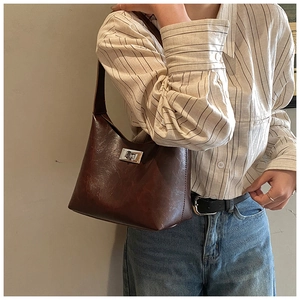 Detailed close-up of dark brown faux leather shoulder bag with silver square twist lock