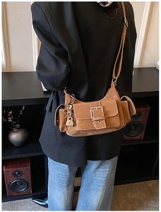 Detailed back view of vintage brown suede crossbody bag with decorative silver buckle