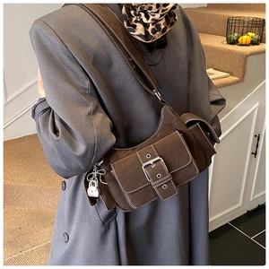 Detail of dark brown retro crescent bag with white stitching and oversized buckle