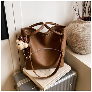 Brown lychee grain leather tote bag featuring a cute plush bear charm with polka dot bow