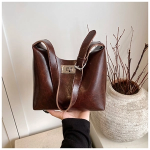 Macro detail of brown leather bag with silver twist lock and adjustable shoulder strap