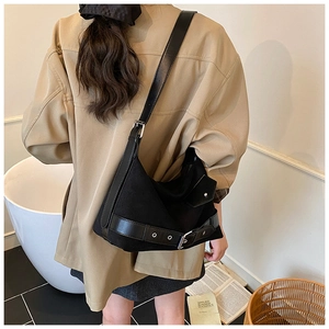Détail du sac cabas en daim noir avec ceinture décorative et boucle argentée chic