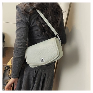 Detail view of mint green pebble leather shoulder bag with silver twist lock and strap
