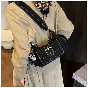 Detail view of retro black canvas shoulder bag with white stitching and metal buckle