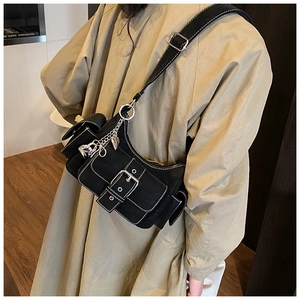 Close-up of black retro shoulder bag featuring white stitching and silver metal chain detail