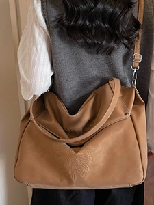 Brown embossed tote bag with dual straps and textured floral pattern for women