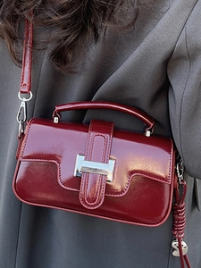 Glossy deep red patent leather handbag with silver buckle for minimalist winter fashion