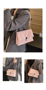 Detail view of pink quilted crossbody bag with silver chain strap and twist lock closure