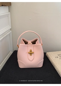 Detail of light pink lychee texture bucket bag with vintage gold metal twist lock