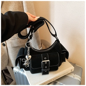 Detail showing black suede underarm bag with white stitching and silver heart charms