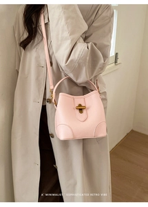 Pale pink lychee grain leather bucket bag with gold metal twist lock and top handle