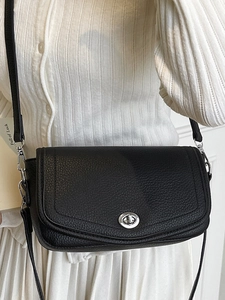 Minimalist black pebble leather underarm bag with silver twist lock on model